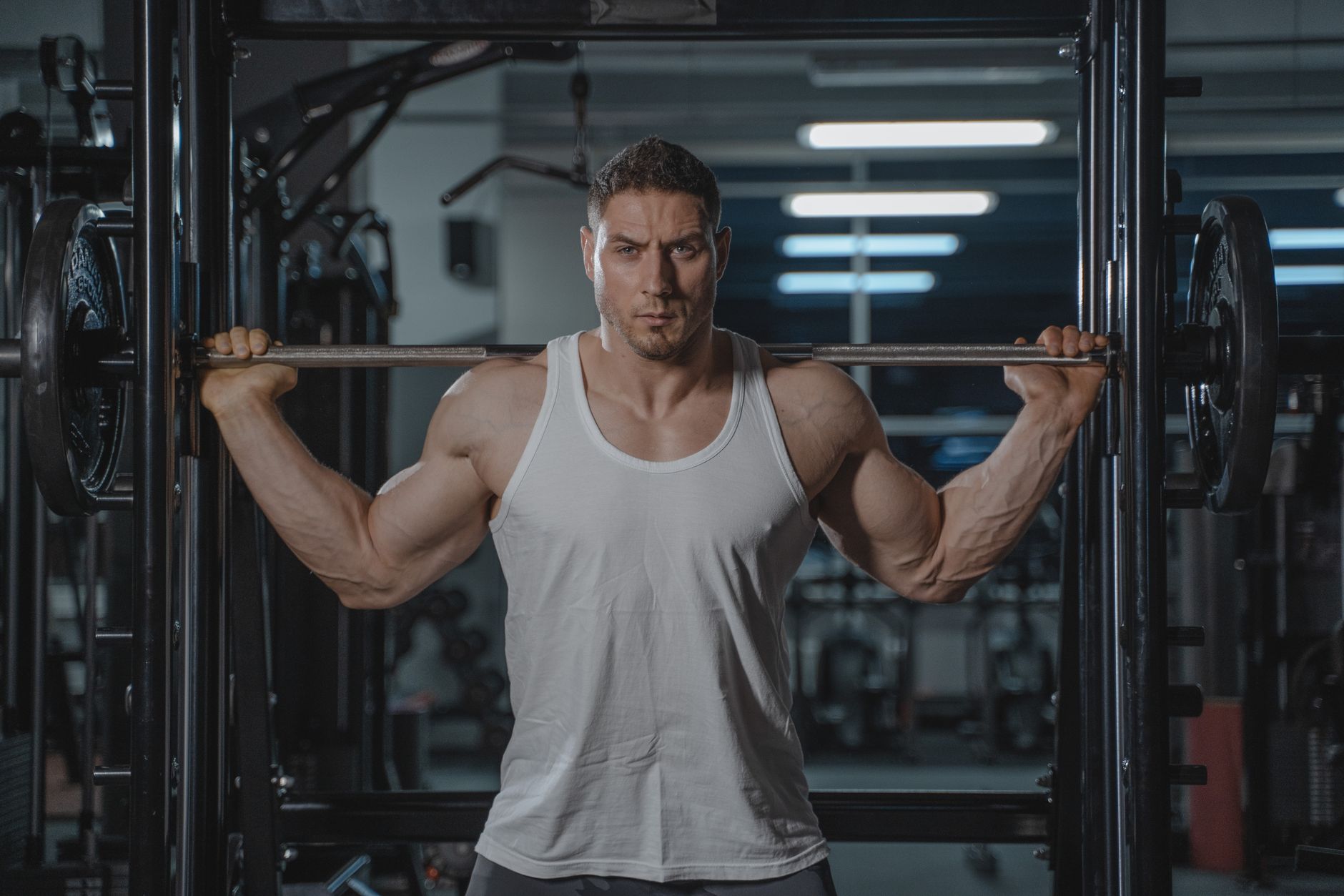 Man lifting weights in a home gym setup with a rack and barbell