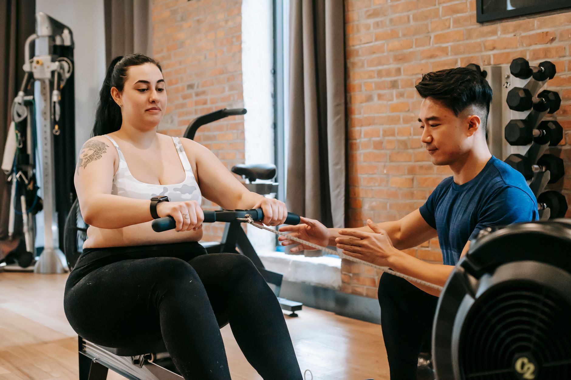 Man intensely rowing on a high-performance rowing machine in a home gym setting.