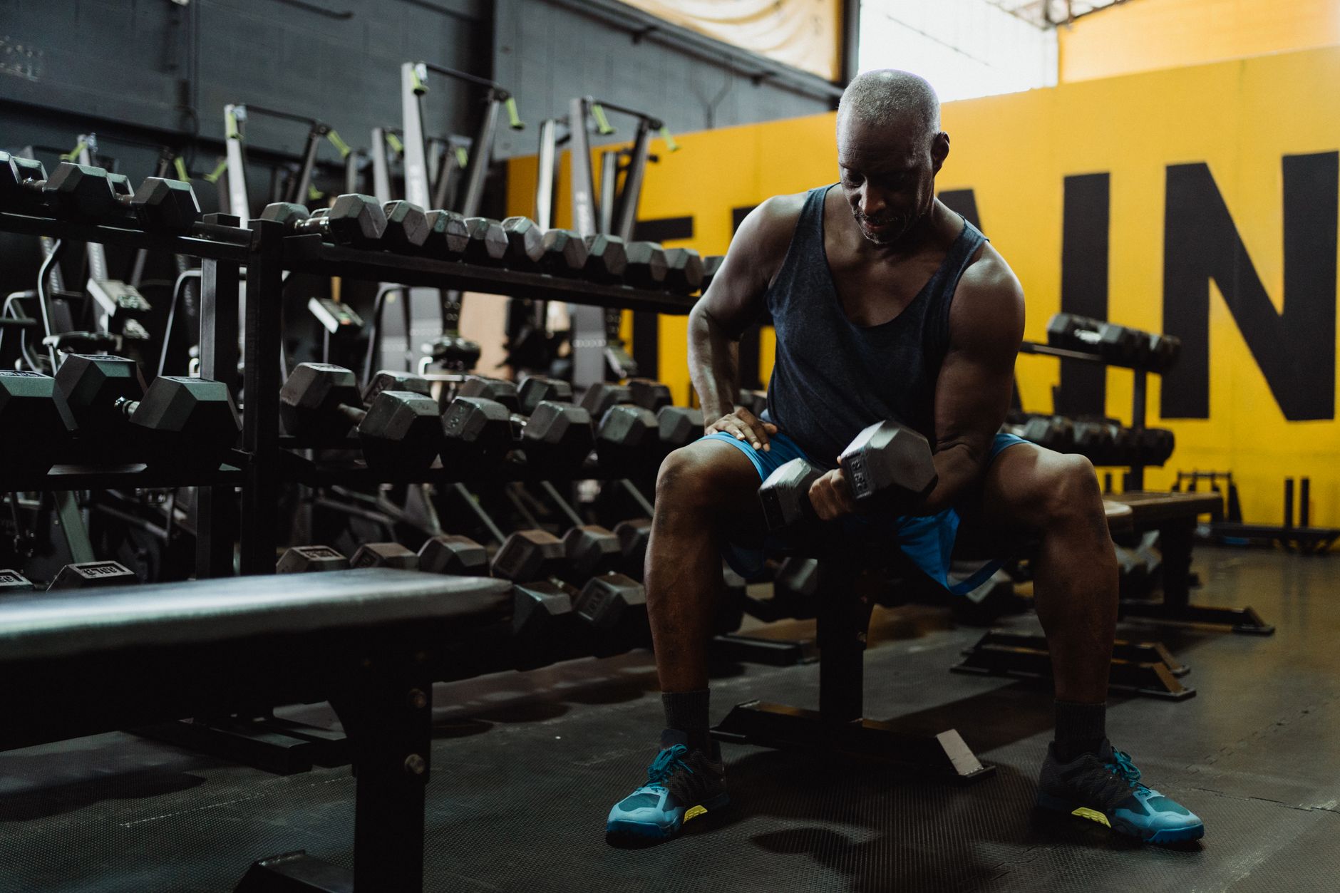 A person performing a bench press on a sturdy weight bench in a home gym setting.
