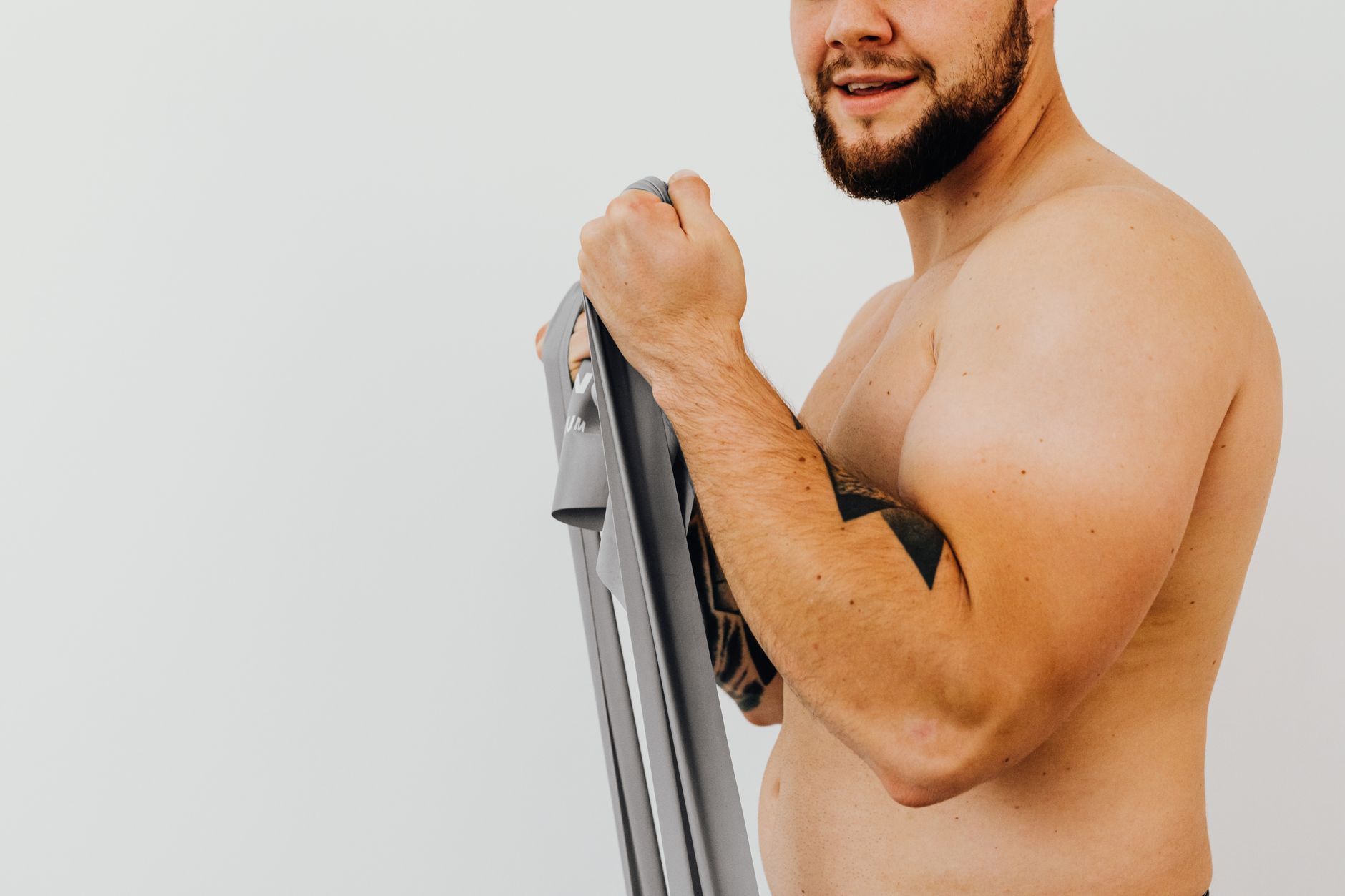 Man performing a resistance band exercise in a home gym setting
