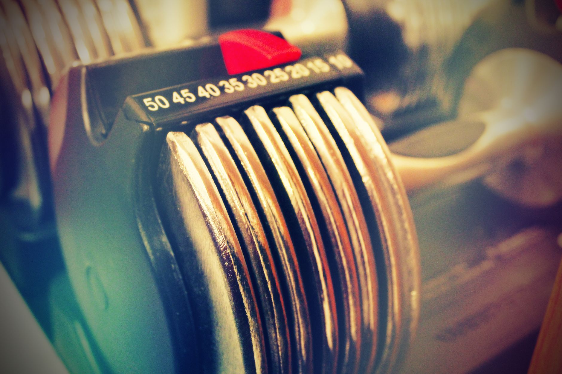 Close-up of an adjustable dumbbell mechanism, highlighting intricate parts susceptible to damage from dropping.