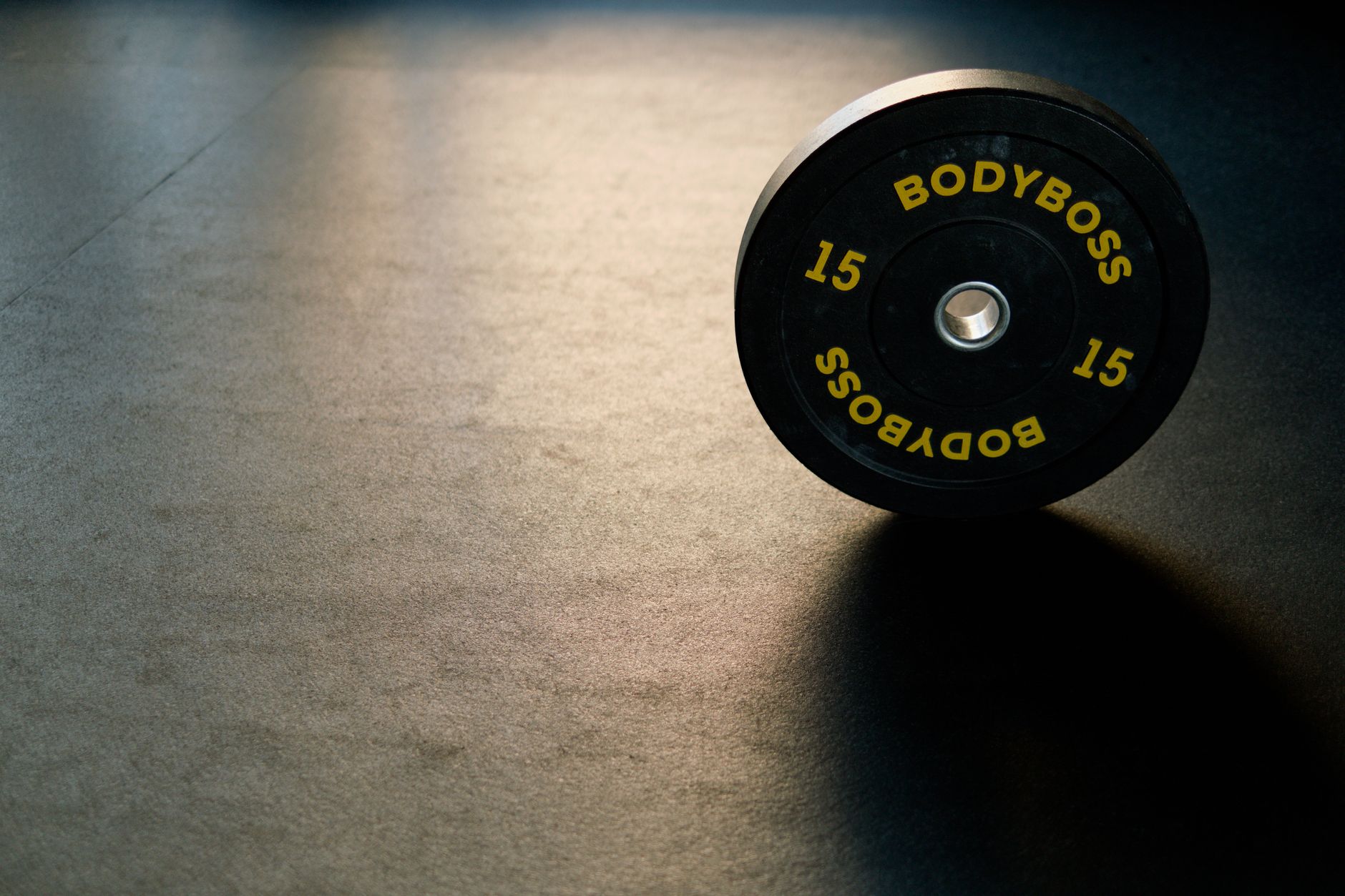 Man performing a barbell floor press in a home gym