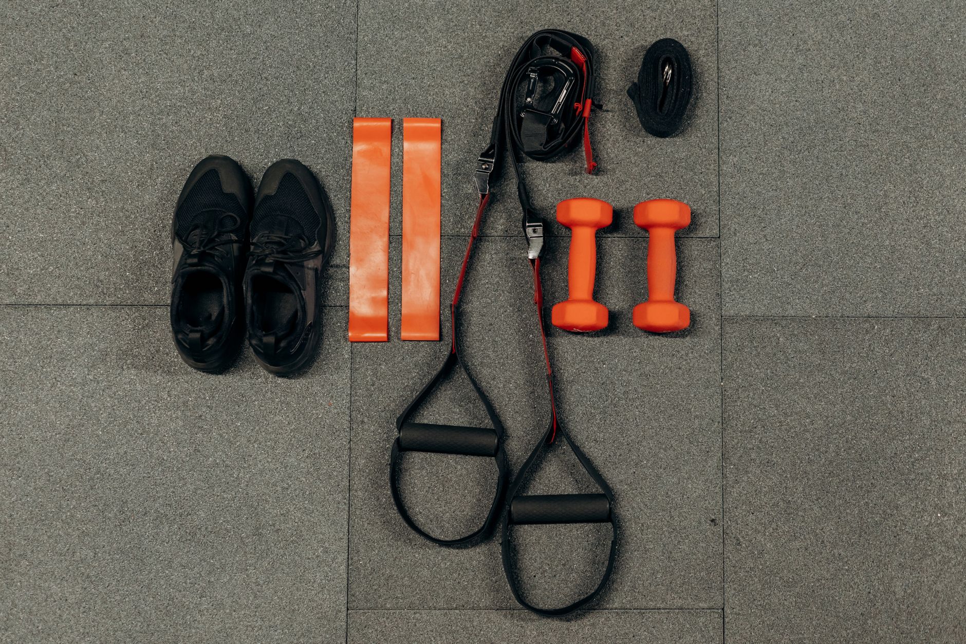A person performing a resistance band squat with a thick band looped around their feet and under their knees.