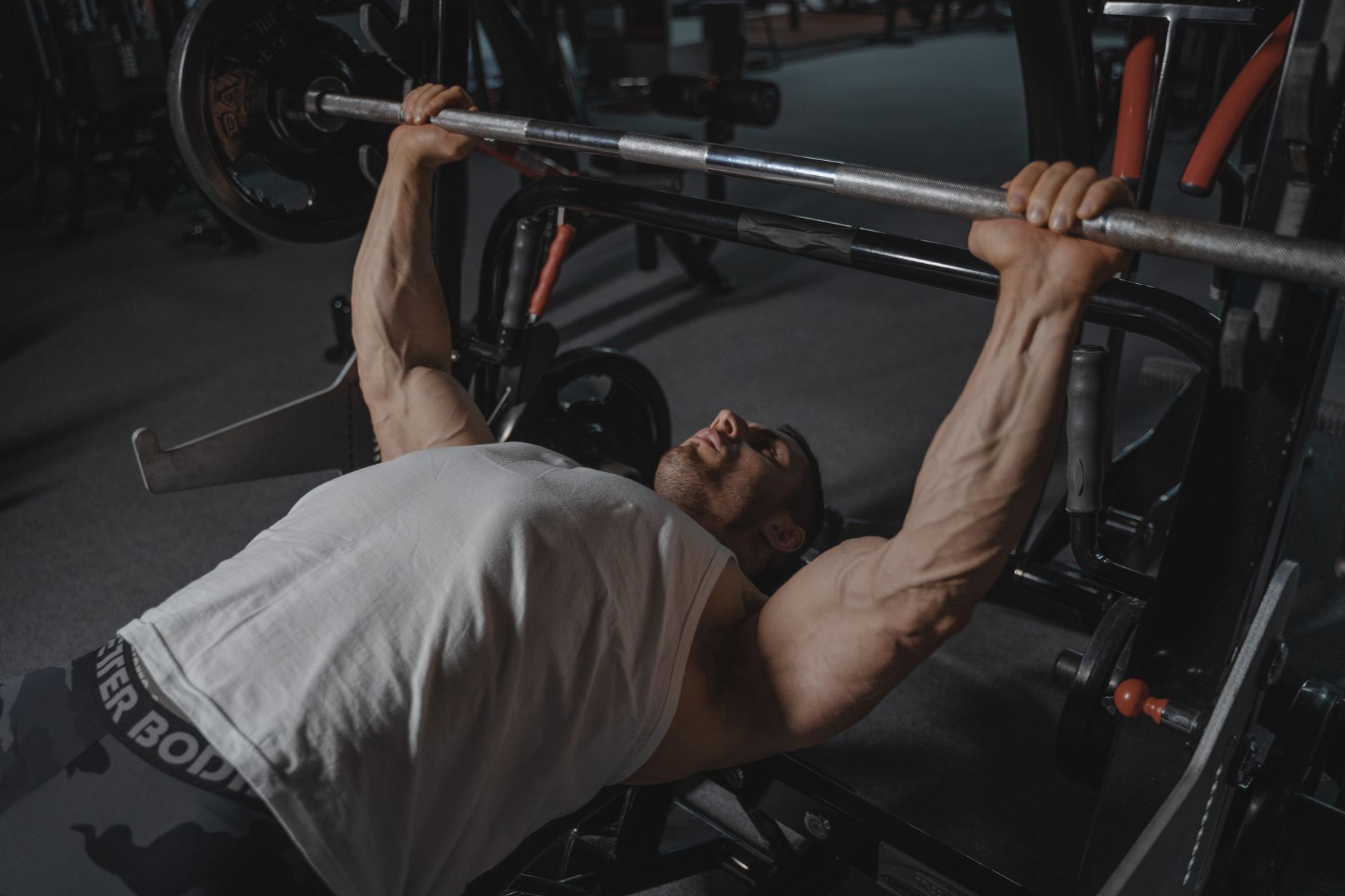 Lifter bench pressing heavy barbell with a powerlifting belt
